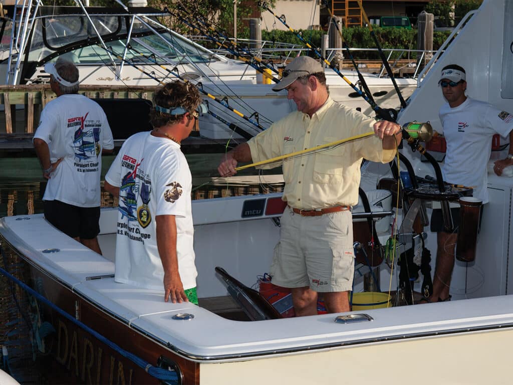 A crew of sport-fishing anglers checking gear and rigging.