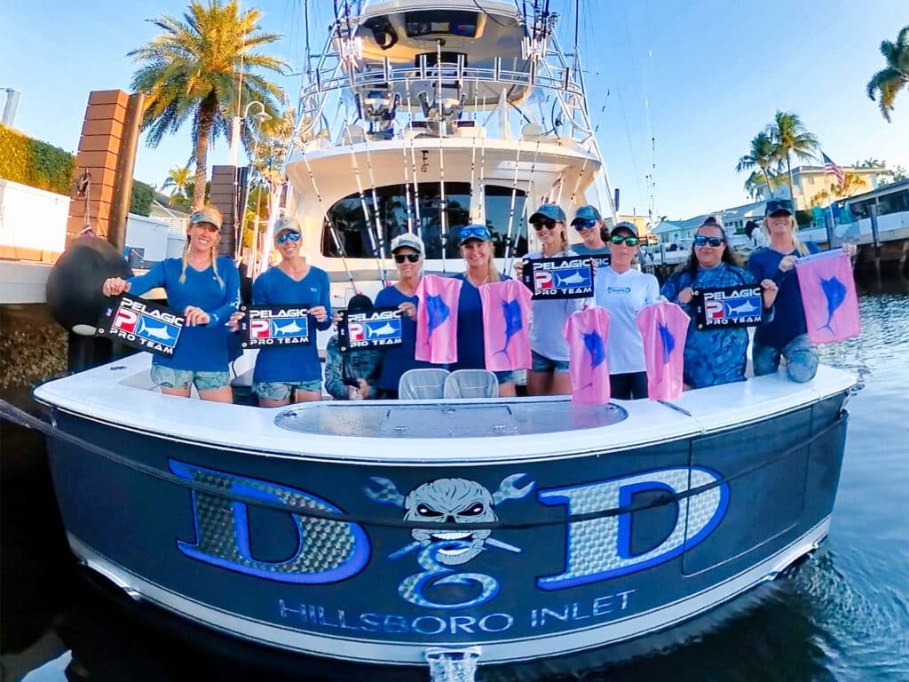 A sport-fishing team standing on a boat deck.