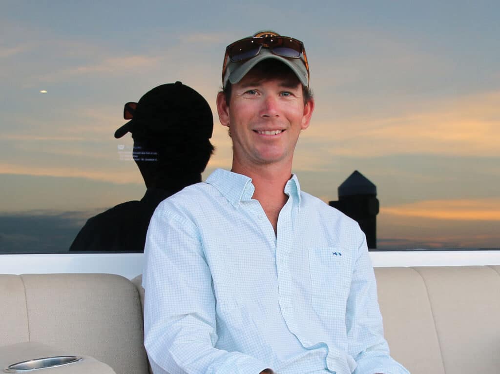 A portrait of Capt. Ryan Easterling sitting in the mezzanine of a sport-fishing boat.