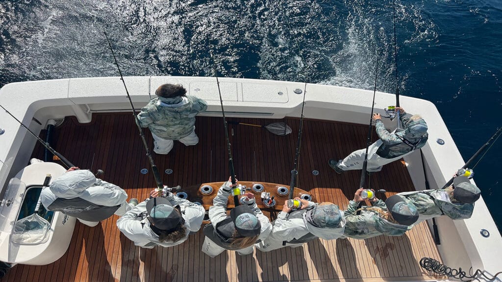 Top down view of the Lady Angler fishing team in the cockpit of a sport-fishing boat.