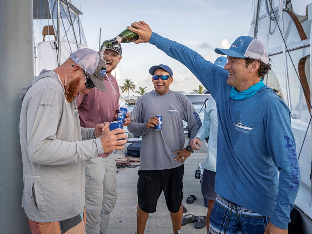 A sport-fishing team celebrates with a champagne shower.
