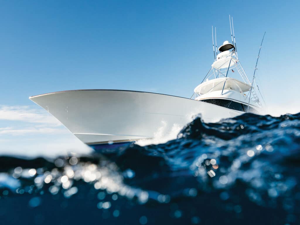 A sport-fishing boat cresting over a wave.