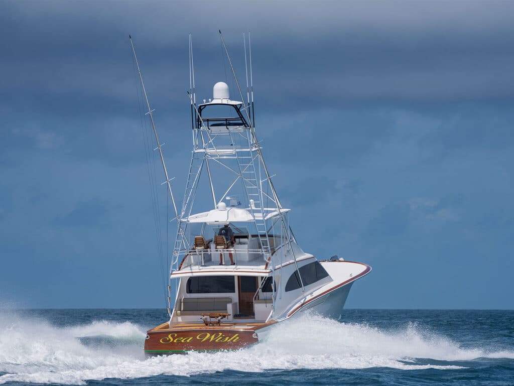 A rear view of a sport-fishing boat cruising a way on the water.
