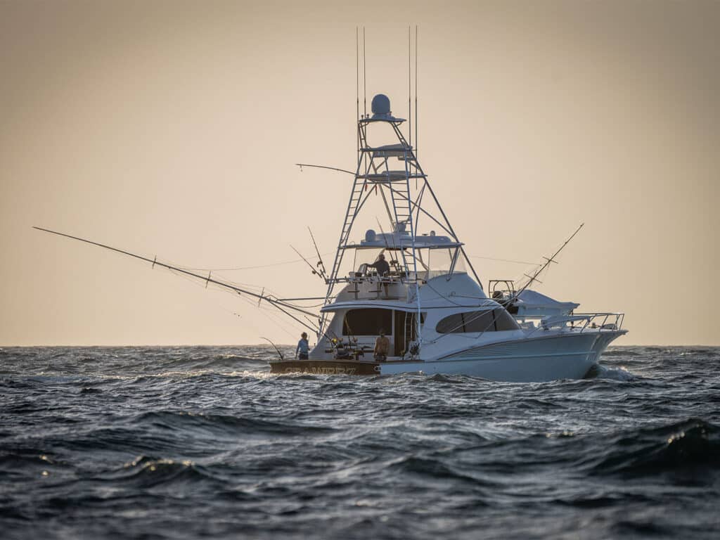 Sea Weez sport-fishing boat on the ocean in low light.