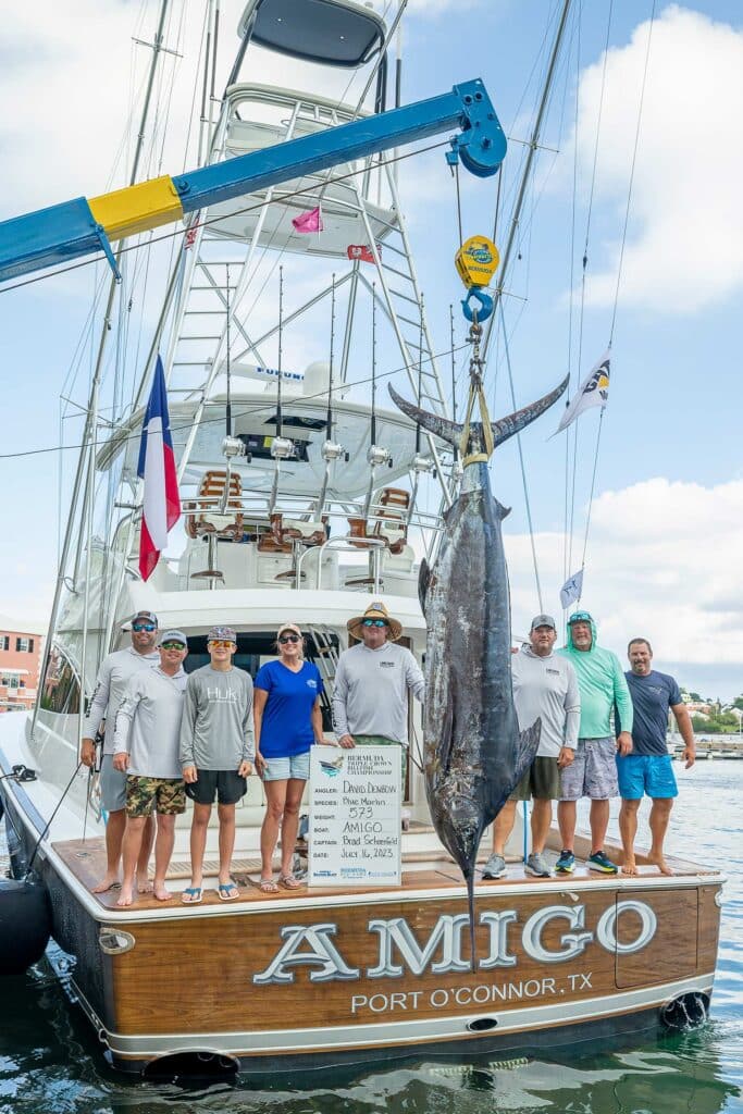A sport-fishing team stands in the cockpit of their boat next to the largest marlin caught at the Bermuda Big Game Classic.