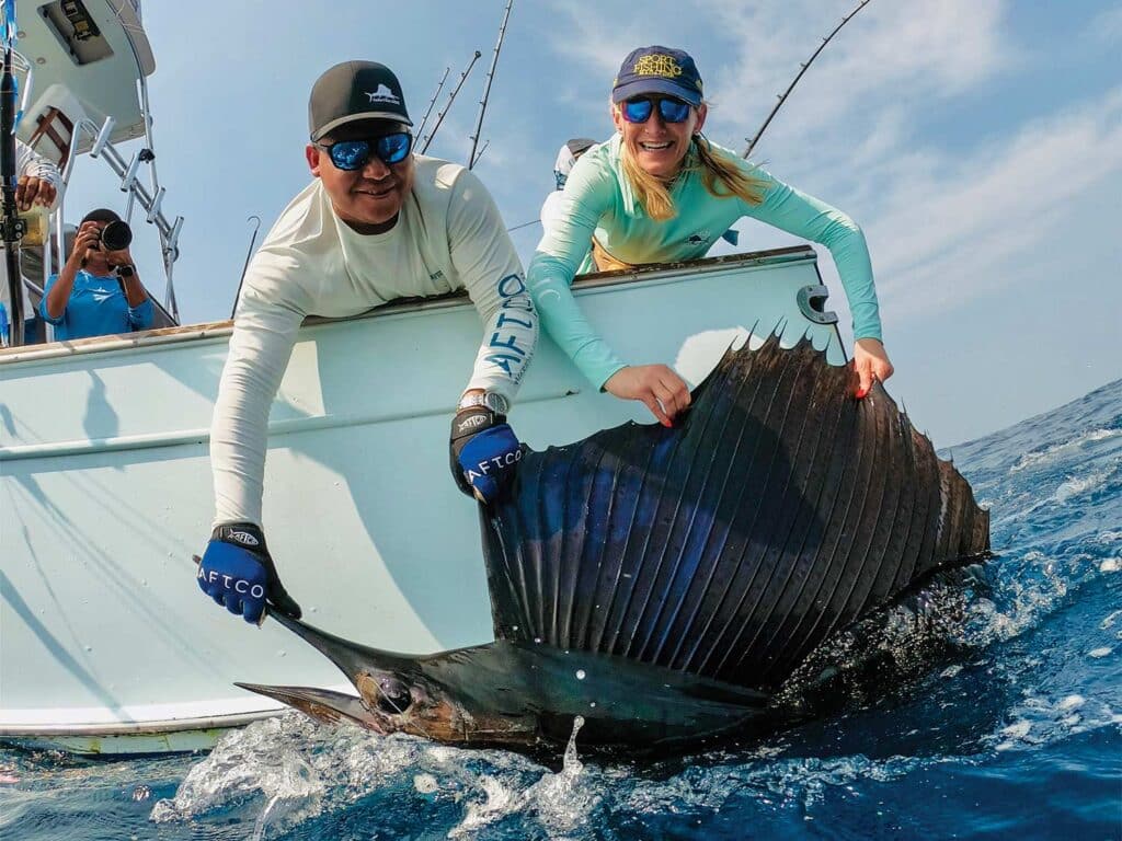 Two crewmates pull a large sailfish boatside in the ocean near Guatemala.