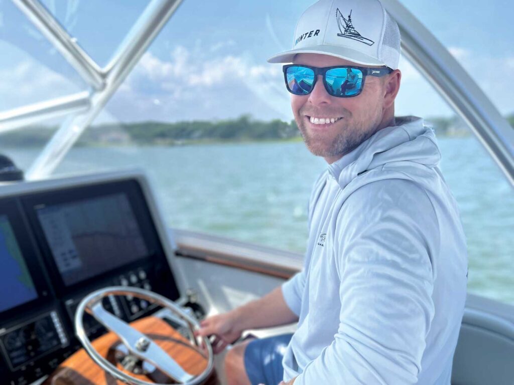 A photo of Tim Winters seated at the helm of a sport-fishing boat.