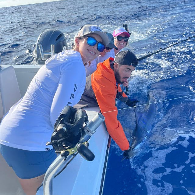 Women with a marlin boatside.