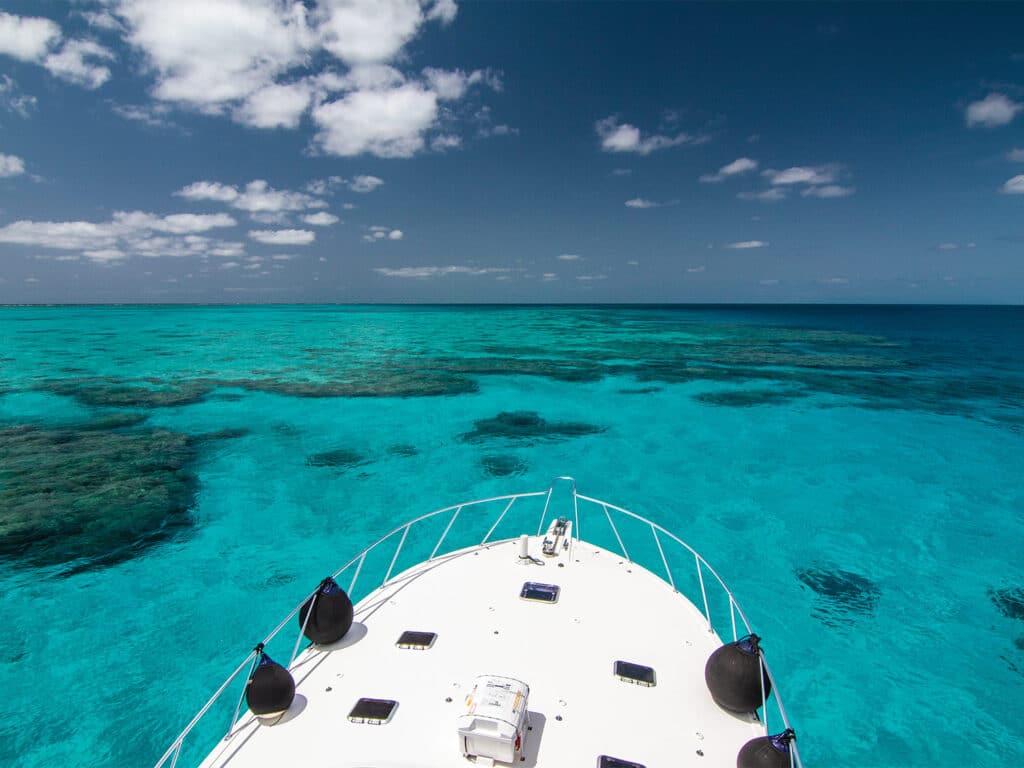 A wide view from the front of a sport-fishing boat, of the ocean's Great Barrier Reef off the shores of Australia.