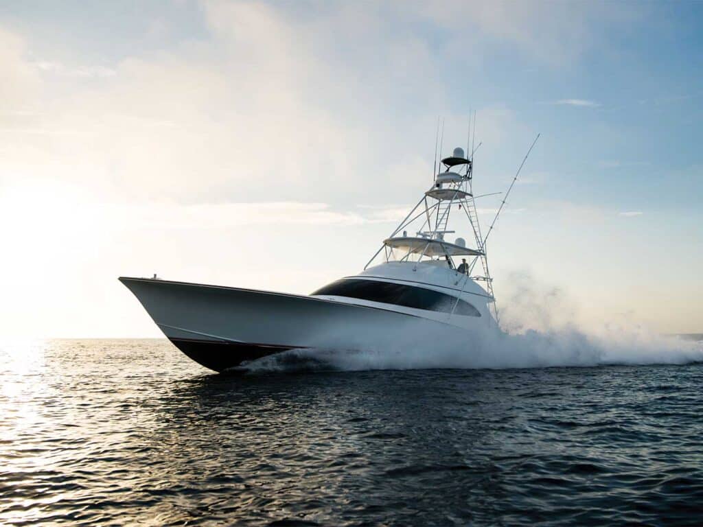 A F&S Boatworks sport-fishing boat cruises across the water in the growing light of day.