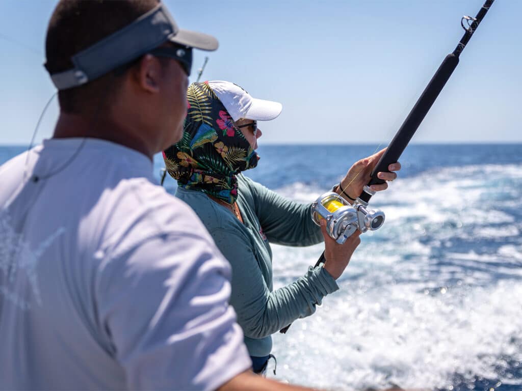 Two anglers casting a line out into the ocean.