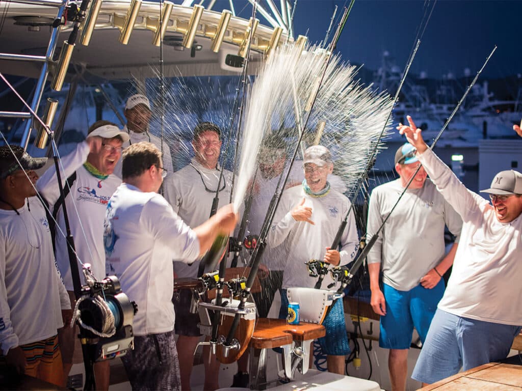 A sport-fishing crew celebrates in the cockpit of a sport-fishing boat by spraying champagne over themselves.
