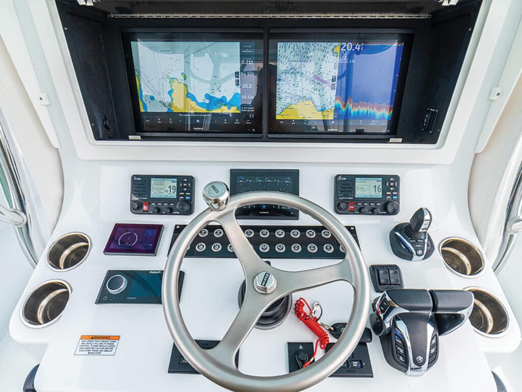 A display of the helm covered in digital displays and marine electronics.