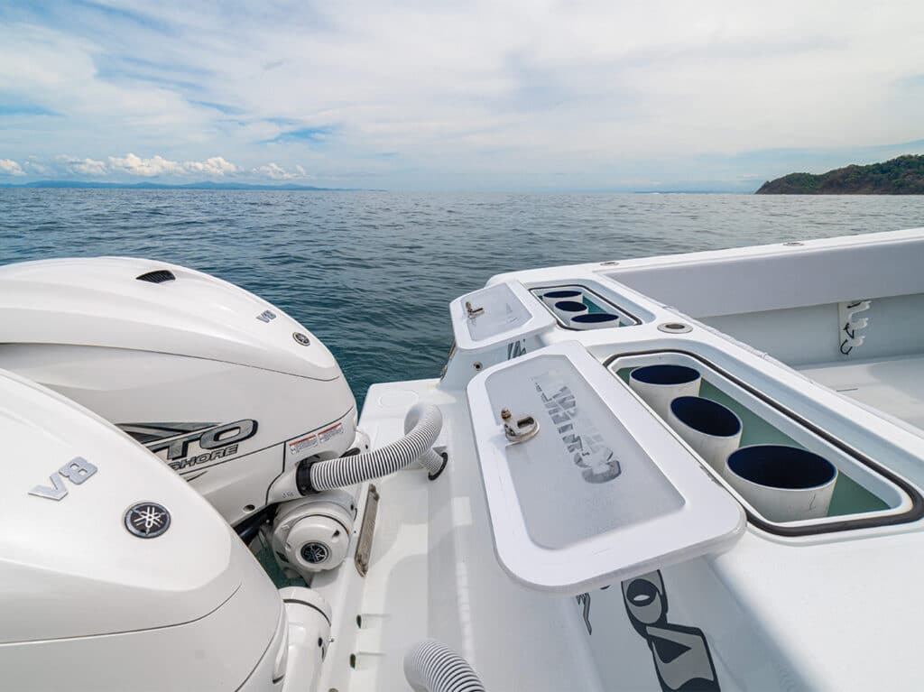 A view of two outboard engines and a livewell built into the cockpit of a sport-fishing boat.