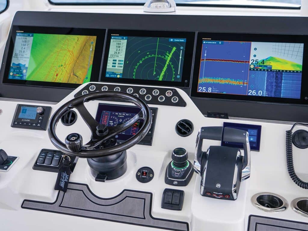 The main helm of a sport-fishing boat featuring electronic displays.