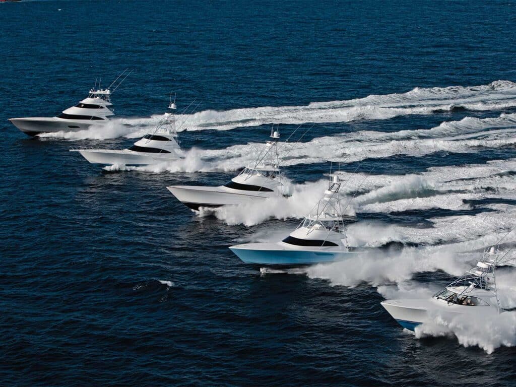 A fleet of sport-fishing boats cruise across the open water.