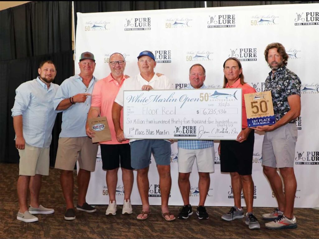 A team of sport-fishers hold an oversized check at the 2023 White Marlin Open awards ceremony.