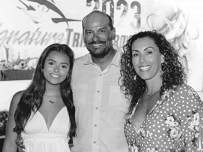 Tony Carrizosa standing with his daughter and fiance at a tournament awards ceremony.