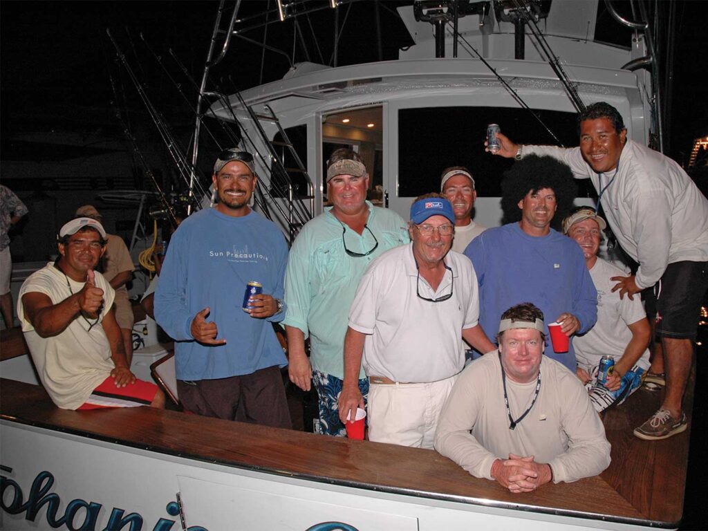 A night-time photo of a sport-fishing team led by Capt. Tony Carrizosa in the cockpit of a sport-fishing boat.