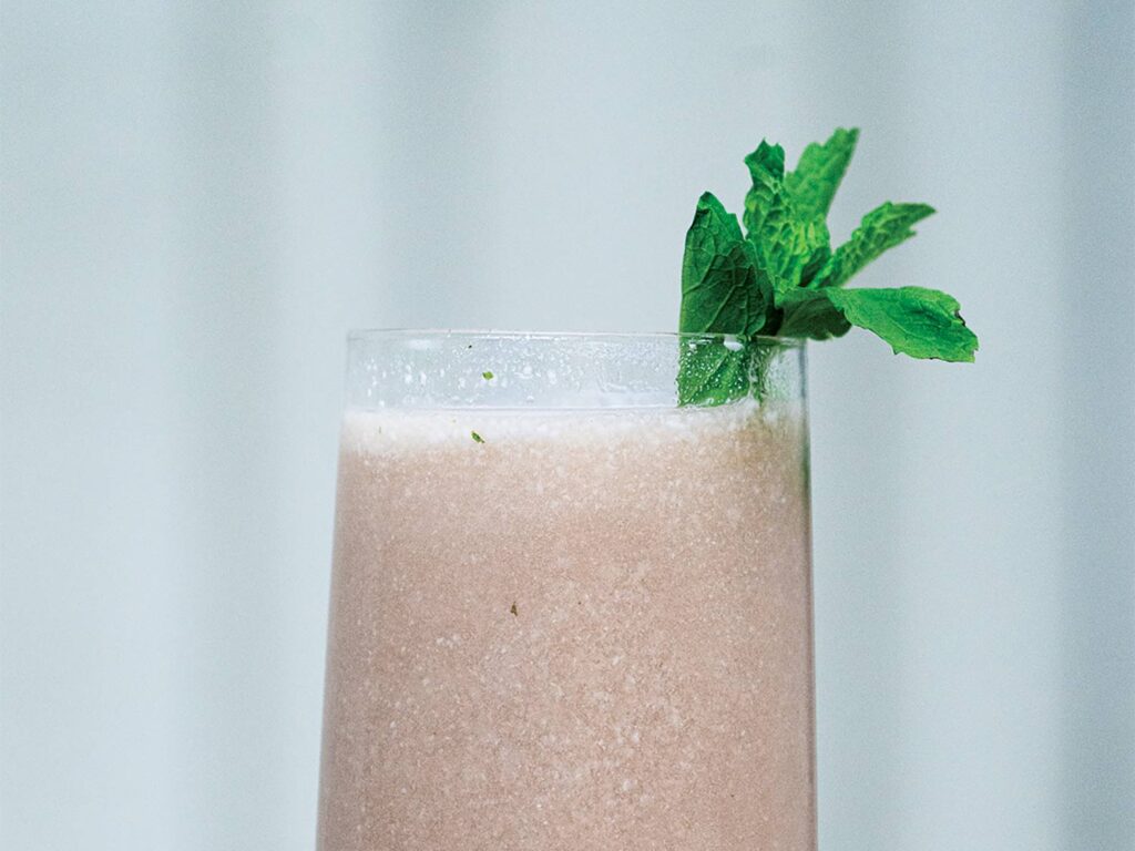 A glass cup of pomegranate coconut lime mojito recipe.