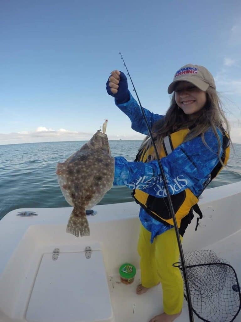 A sport-fishing angler holds up a large Atlantic Flounder.