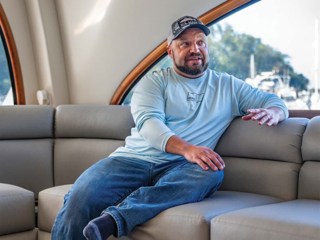 John Floyd sits for an interview in the seating of a sport-fishing boat.