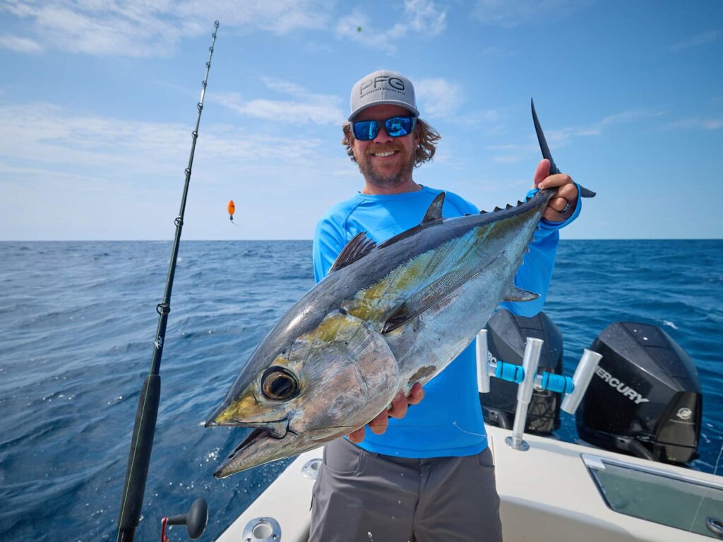 An angler holding up a large blackfin tuna.
