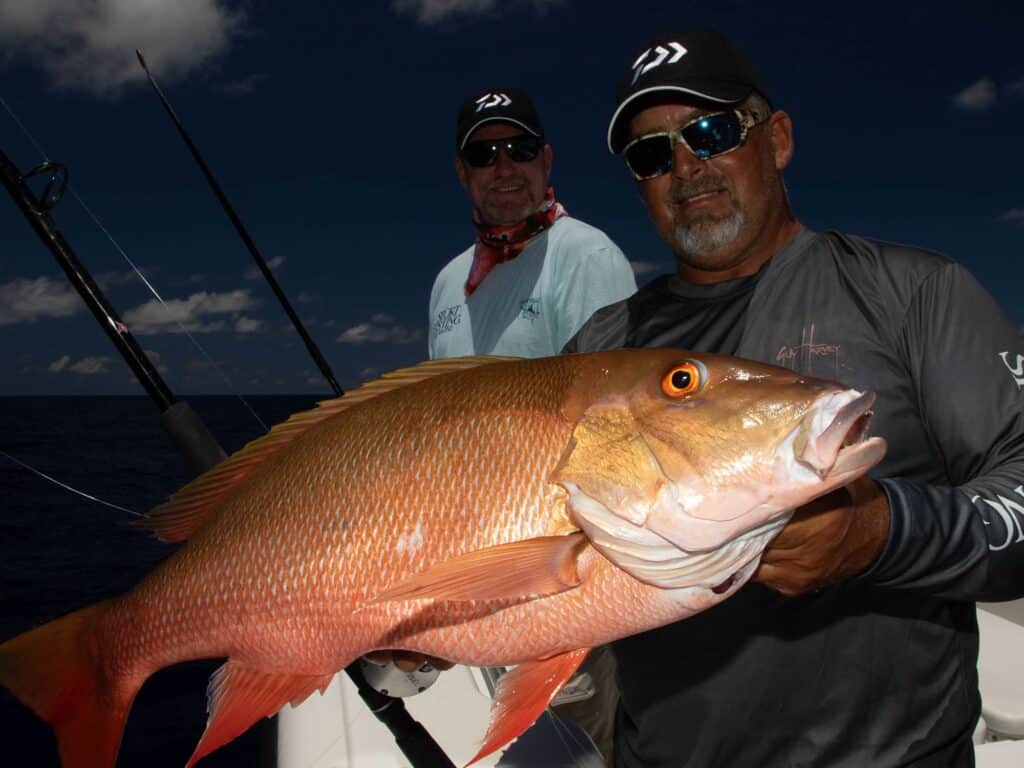 An angler holding up mutton snapper.