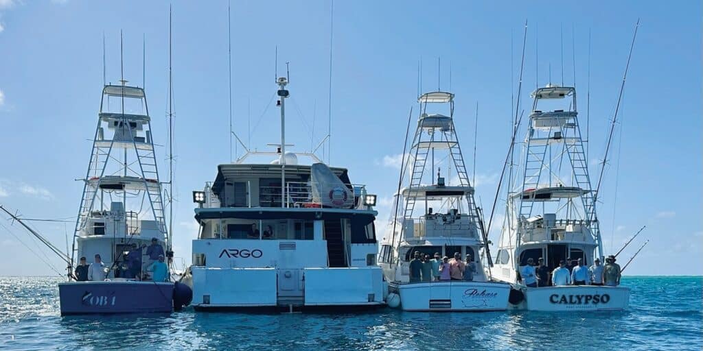 Three sportfishing boats and a mothership on the waters of Australia's Great Barrier Reef.