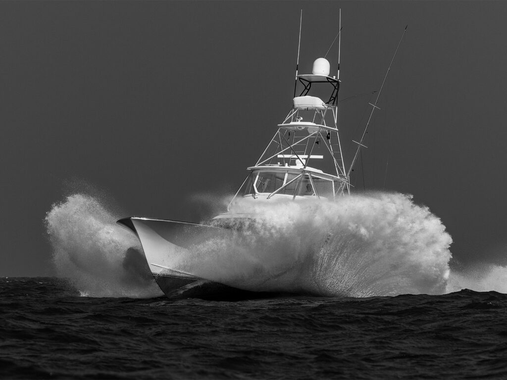 A sport-fishing boat splashes through the ocean.