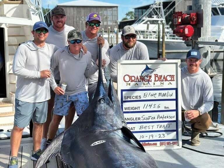 Team Best Trait stand at the docks in Orange Beach, next to a grander marlin.