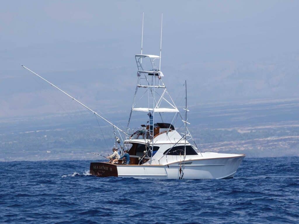 A sport-fishing boat with an angler in the cockpit in the waters of Hawaii.