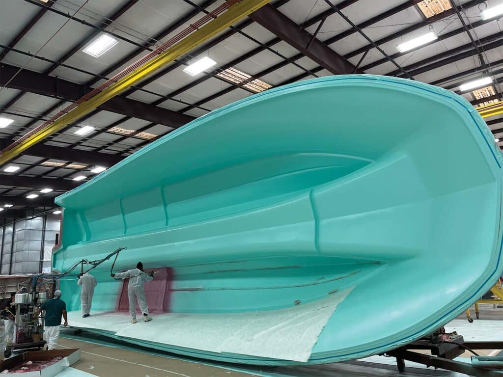A 56 foot catamaran hull being worked in a warehouse.