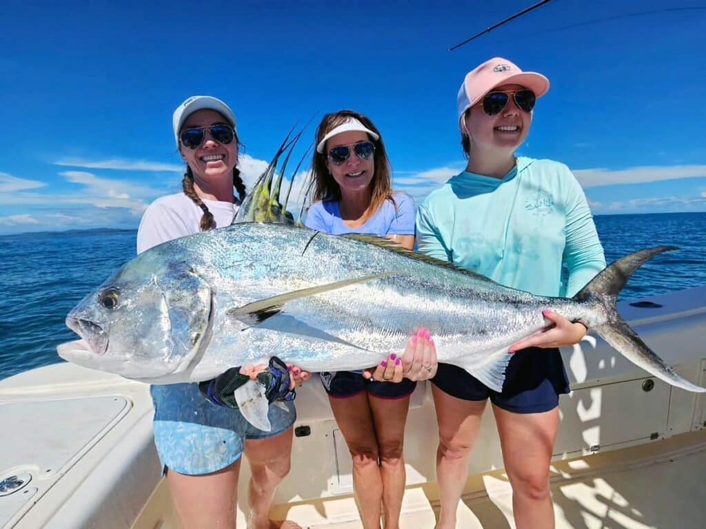 Three anglers holding a large tuna.