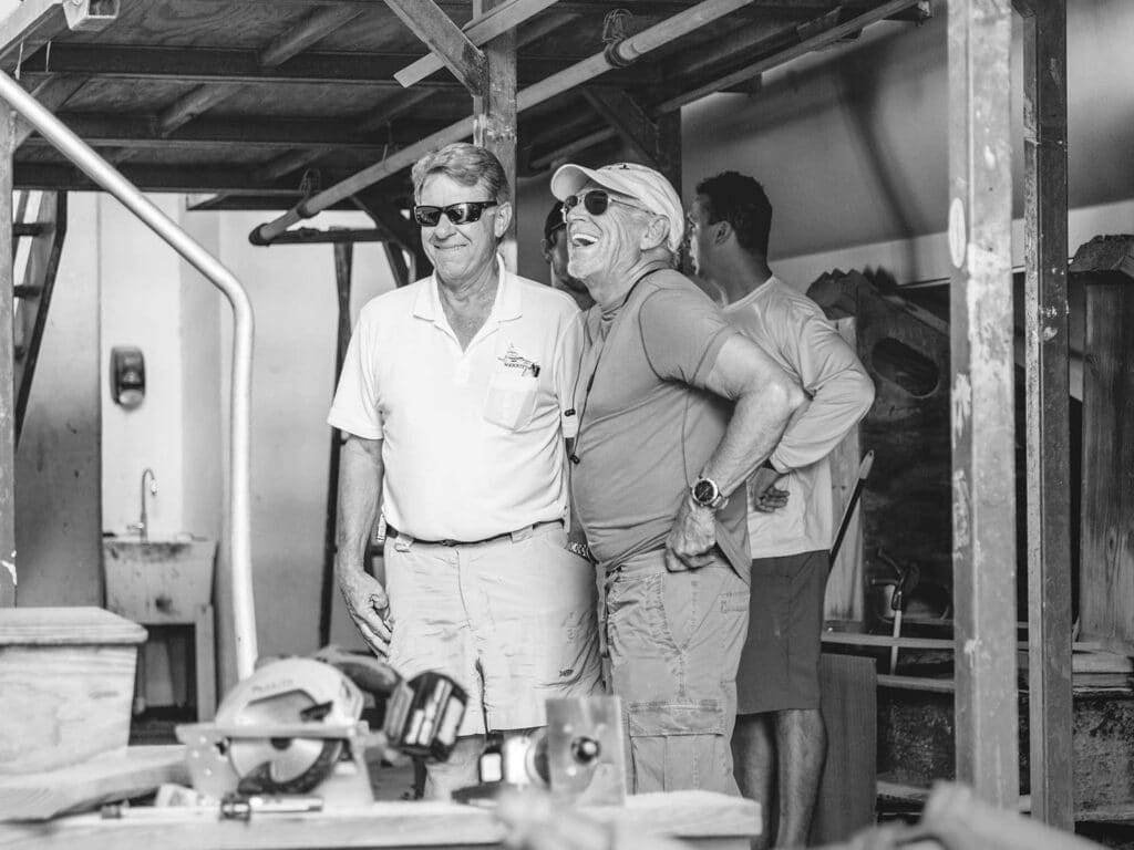 A black and white image of Jimmy Buffett and Roy Merritt standing in a warehouse.