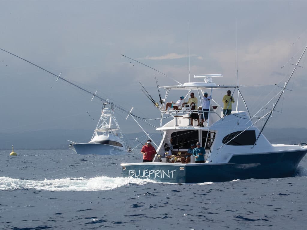 Two boats cruise past a FAD device floating in the water.