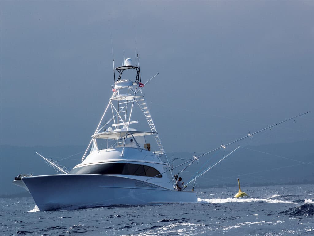 A sport-fishing boat cruises past a FAD in the water while trolling for fish.