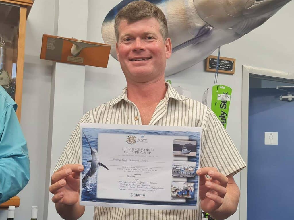 An angler holding up an Offshore World Championship qualifying certificate.