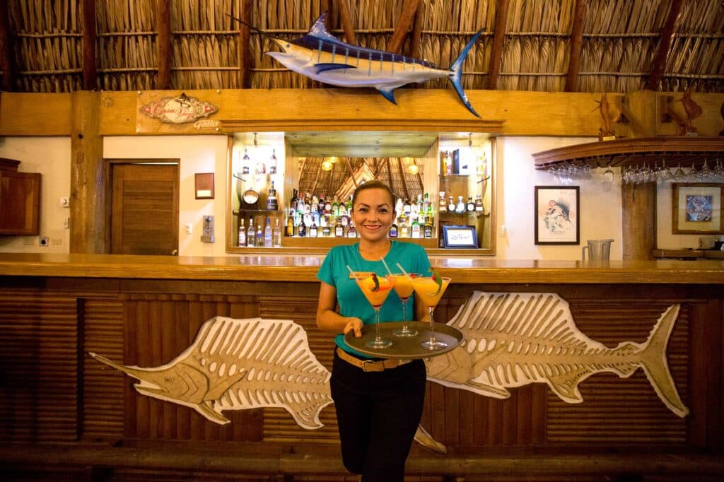 An attendant holding up a tray of cocktails at the Casa Vieja Lodge bar.