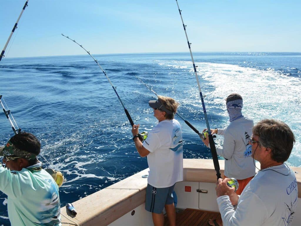 Four anglers fishing from the cockpit of a sport-fishing boat.