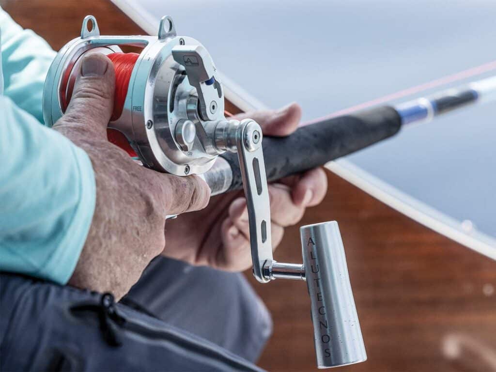 Close up detail of an angler holding his fishing rod with two hands.