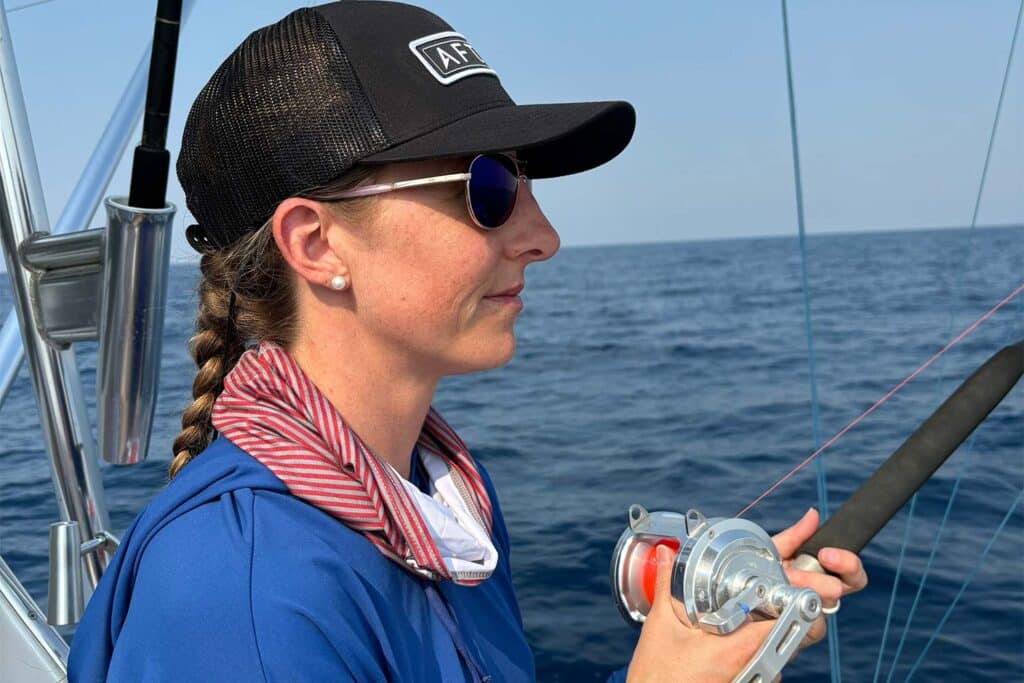 A woman looks out over the horizon as she prepares for a day of fishing.