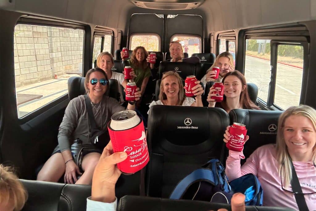 A group of women riding passenger in a bus having a drink while en route to their destination.