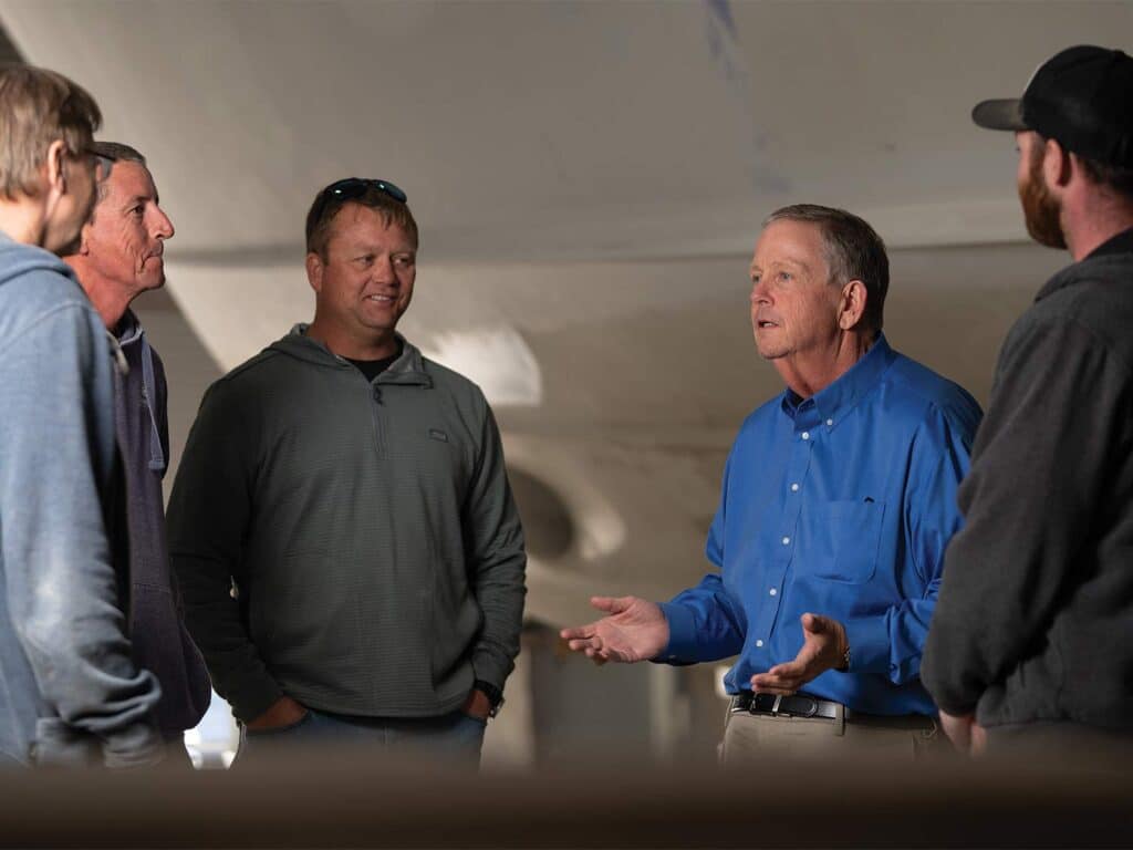 A group of men stand around and chat.