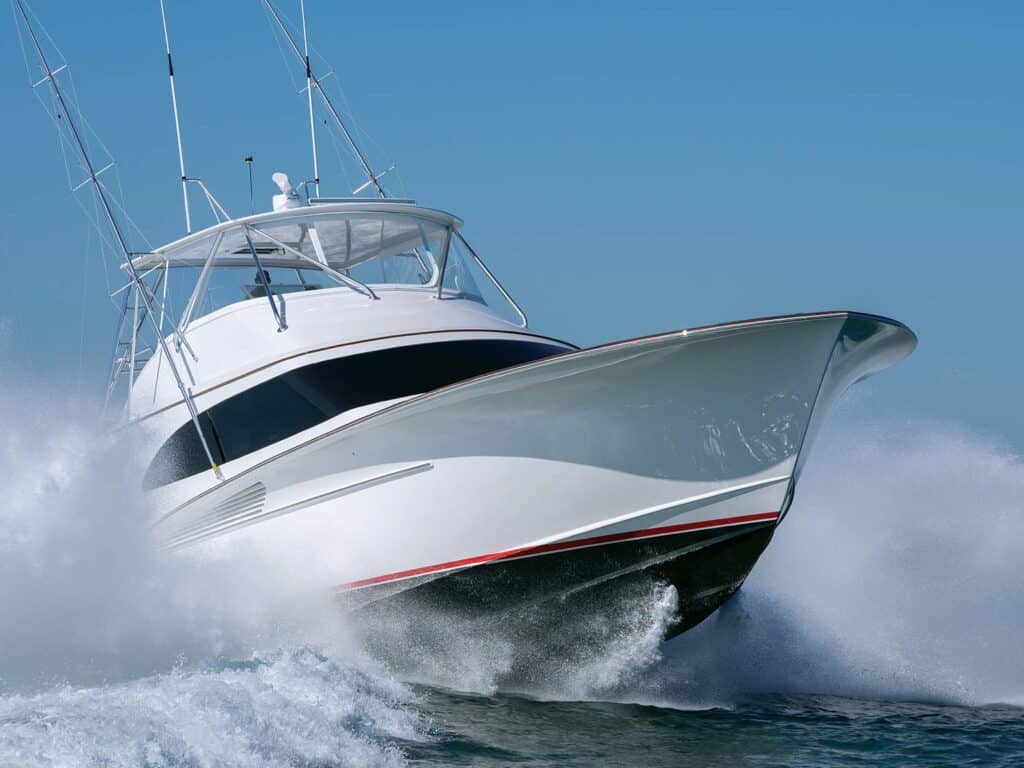A sport-fishing boat on the water with waves splashing against its hull.