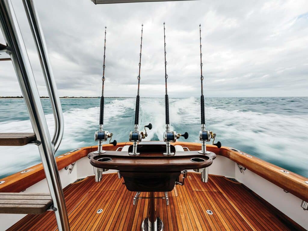 Four fishing reels in the fighting chair of a sport-fishing boat.