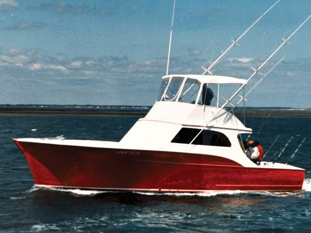 A red-hulled sport-fishing boat on the water.