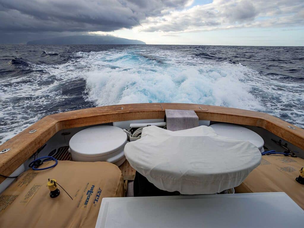 View of a sport-fishing boat cockpit packed down with gear and supplies.