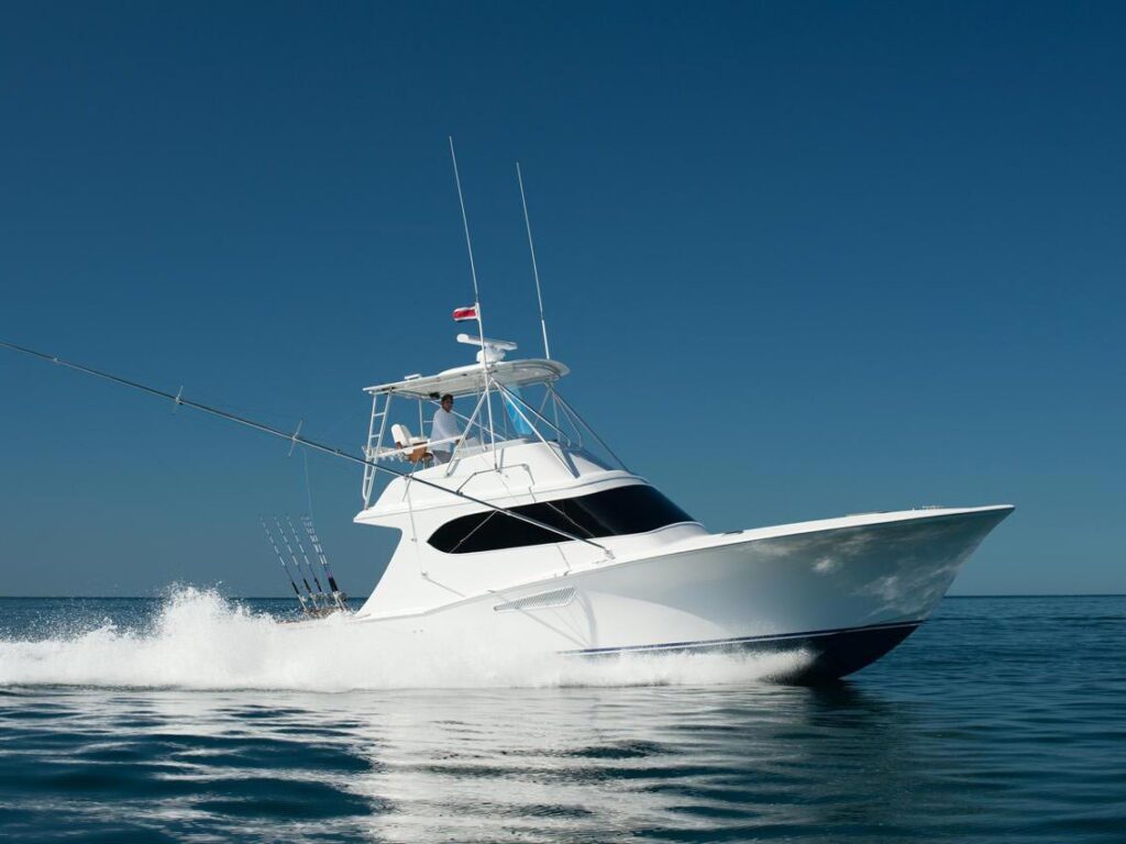 The Tijereta sport-fishing boat cruises across the ocean, leaving cresting waves in its wake.