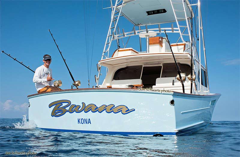 View of Bwana's transom showing its name in script. A single angler sits in the cockpit.